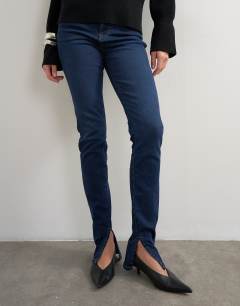 Model wearing Skinny high rise jean with side split in rinse
