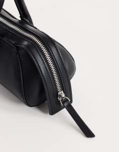 Model wearing Skylar medium elongated bowler bag in black