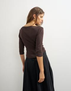 Model wearing Slash neck curve hem top in chocolate