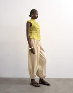 Model wearing Sleeveless pin tuck crinkle top in green