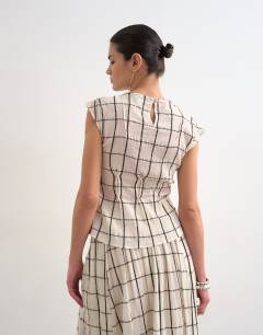 Model wearing Sleeveless pin tuck crinkle top in windowpane check