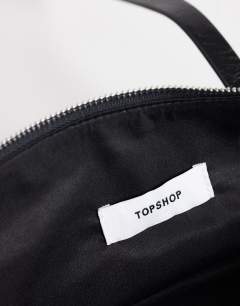 Model wearing Snoopy small zip front pocket shoulder bag in black