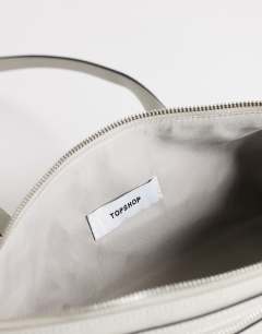 Model wearing Snoopy small zip front pocket shoulder bag in light grey
