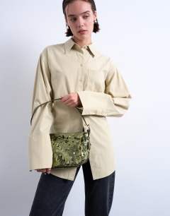 Model wearing Sol shoulder sequin bag with leather handle in khaki