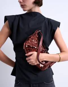 Model wearing Sol shoulder sequin bag with leather handle in rust