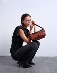 Model wearing Sol shoulder sequin bag with leather handle in rust