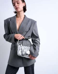 Model wearing Sol shoulder sequin bag with leather handle in silver