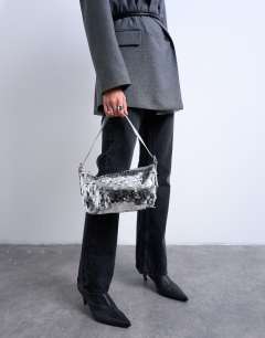 Model wearing Sol shoulder sequin bag with leather handle in silver