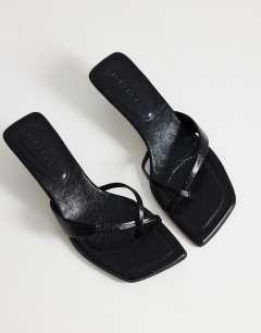 Model wearing Solo strappy mule mid heel sandal in black