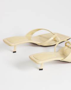 Model wearing Solo strappy mule mid heel sandal in buttermilk