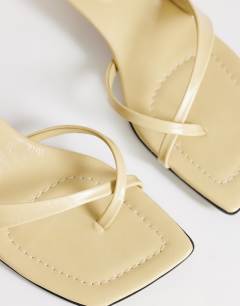 Model wearing Solo strappy mule mid heel sandal in buttermilk