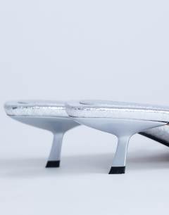 Model wearing Solo strappy mule mid heel sandal in silver