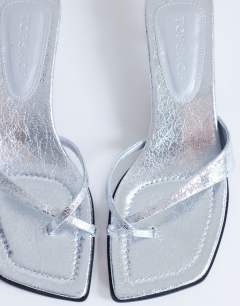 Model wearing Solo strappy mule mid heel sandal in silver