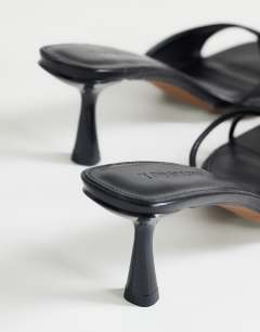 Model wearing Sophie asymmetric mid heel mule in black