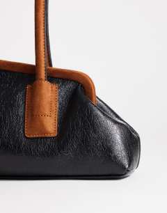 Model wearing Sophie medium angular shoulder bag in black and tan