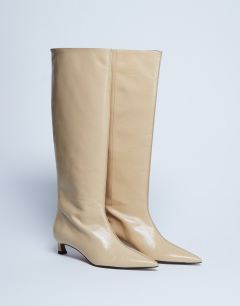 Model wearing Sophie Premium leather point toe knee high boot in buttermilk