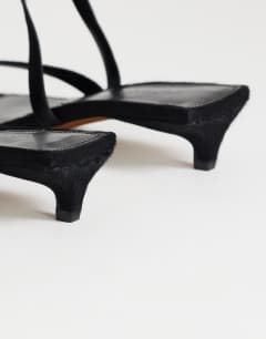 Model wearing Sophie strappy mid heel sandal in black print hair on real leather