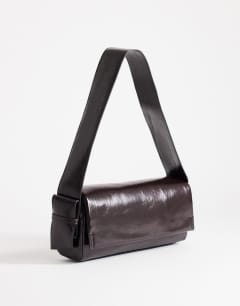 Model wearing Spencer strap detail shoulder bag in chocolate