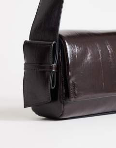 Model wearing Spencer strap detail shoulder bag in chocolate
