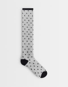 Model wearing Spot sheer knee-high socks in black