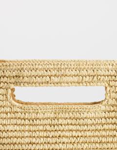 Model wearing Stella straw small grab bag in natural