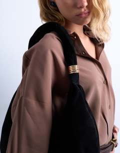Model wearing Sterling real suede scoop shoulder bag in black