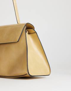 Model wearing Stevey medium shoulder bag in buttermilk