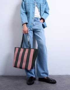 Model wearing Stevie striped faux leather tote bag in pink & khaki