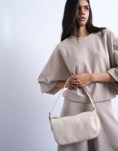 Model wearing Stina real leather shoulder bag in off white pony
