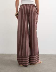 Model wearing Stripe tie waist wide leg trouser in brown and pink