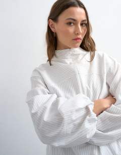 Model wearing Stripe zip long sleeve cuffed top in white