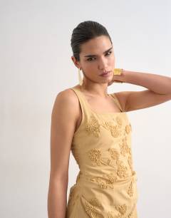 Model wearing Structured drape mini dress with 3D flowers in beige