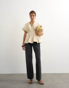 Model wearing Structured peplum top with pintucks in stone