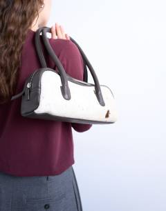 Model wearing Sullivan real leather shoulder bowler bag in cow print pony