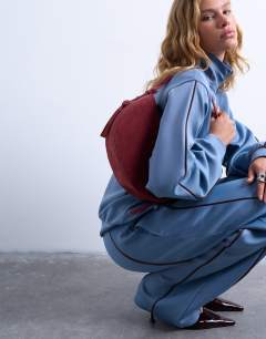 Model wearing Sunday leather suede shoulder bag in red