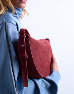 Model wearing Sunday leather suede shoulder bag in red