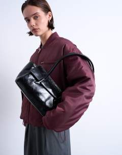 Model wearing Sunny shoulder bag with asymmetric flap in black