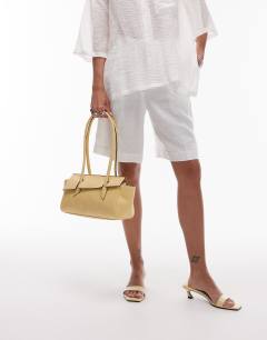 Model wearing Sunny shoulder bag with asymmetric flap in lemon