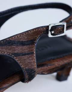 Model wearing Sunshine toe thong mid heel sandal in brown zebra hair on real leather 