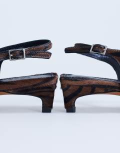 Model wearing Sunshine toe thong mid heel sandal in brown zebra