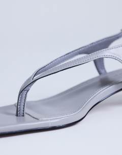 Model wearing Sunshine toe thong mid heel sandal in grey hair on real leather