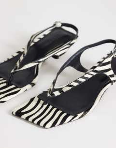 Model wearing Sunshine toe thong mid heel sandal in zebra hair on real leather