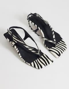Model wearing Sunshine toe thong mid heel sandal in zebra hair on real leather