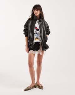 Model wearing Super oversized toggle waist leather look funnel zip through jacket in black