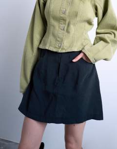 Model wearing Super soft cupro mini skirt in black