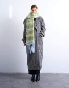 Model wearing Sydney blanket scarf in green & white stripe