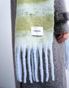 Model wearing Sydney blanket scarf in green & white stripe