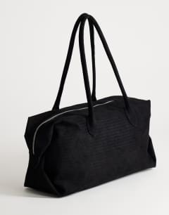 Model wearing Tabby suedette weekend bag in black weave
