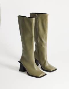 Model wearing Tabitha extended rand knee high heeled boot in green