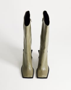 Model wearing Tabitha extended rand knee high heeled boot in green
